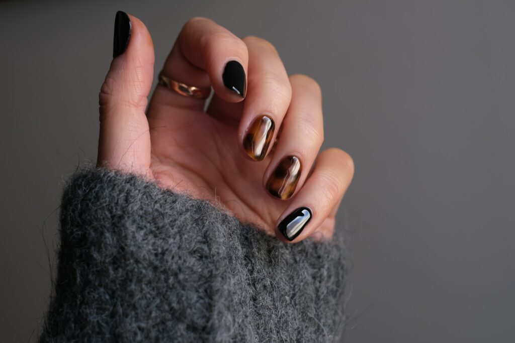 SNS Nails - womans hand showing of tortoise shell manicure