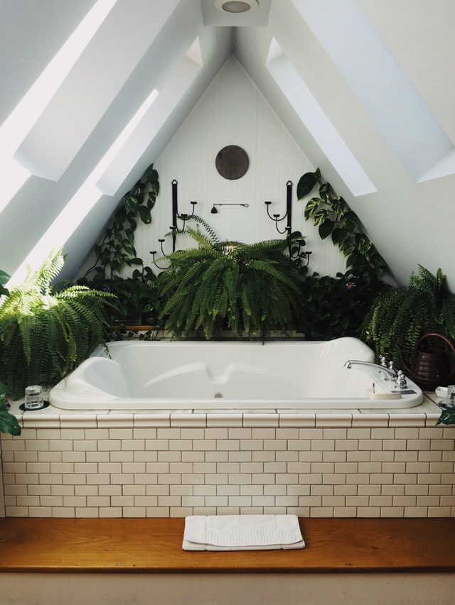 2022 self-care trends - header image of blog - bath in A frame home surrounded by plants