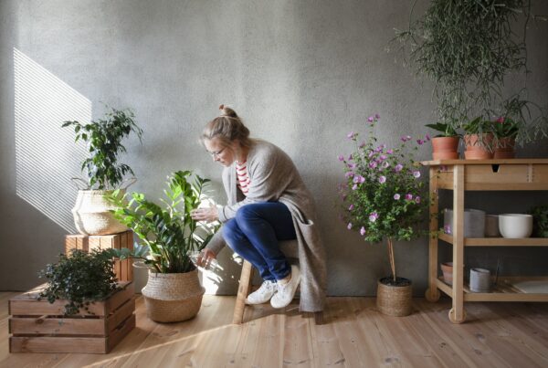 woman-tending-to-potted plants-in-indoor-garden